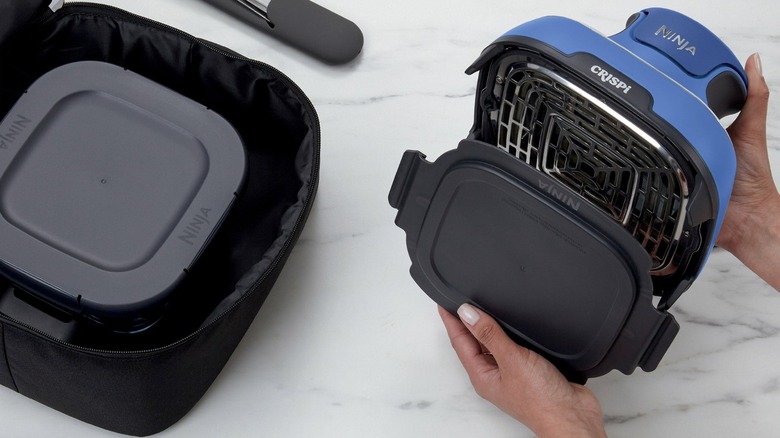 Person removing PowerPod of Ninja Crispi 5-in-1 Air Fryer