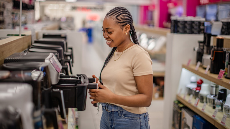 A woman in a store looking at air fryers