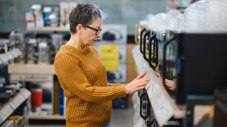 A woman shopping in the small appliance section of a store