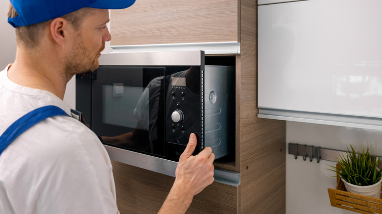 service worker installing integrated microwave oven in the domestic kitchen