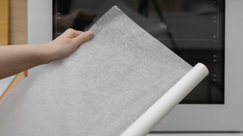 Person rolling out a sheet of parchment paper