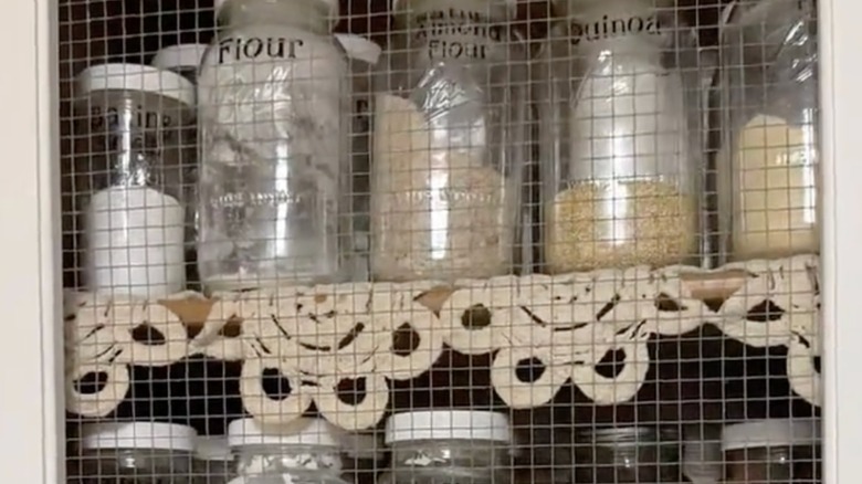 crocheted doily used as a shelf liner under glass containers