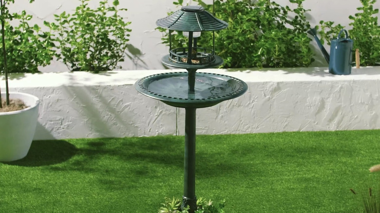 Best Choice Products' Solar Outdoor Birdbath in a garden with stone wall and astroturf
