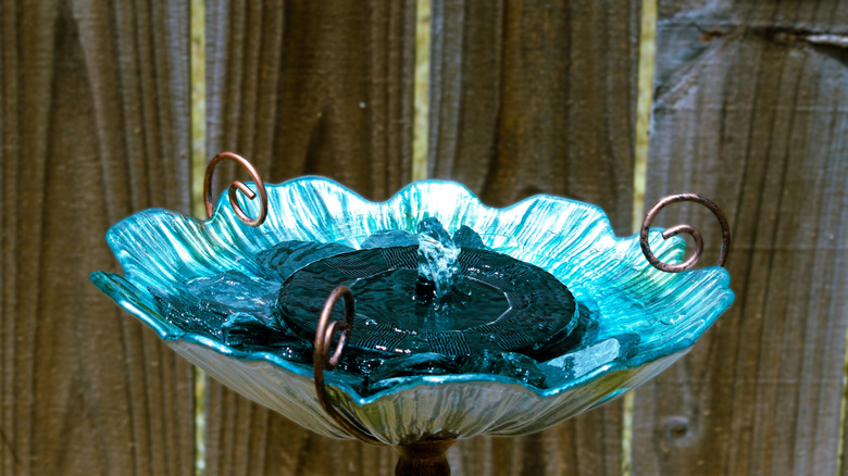 A beautiful blue-glass birdbath with a solar fountain