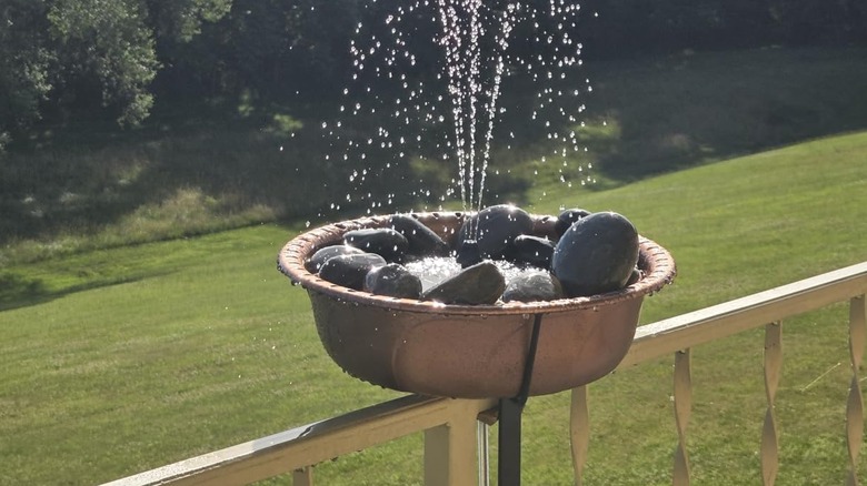 VIVOHOME's Deck-Mounted Birdbath with Solar Fountain mounted on deck railing in back yard