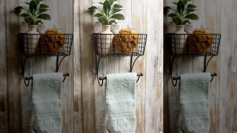 A wall-mounted basket with a built-in towel bar installed on a rustic wood wall.