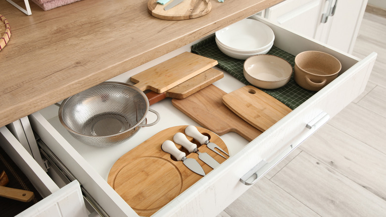 An opened drawer with utensils in a kitchen.