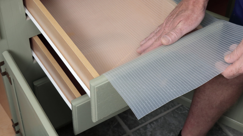 Person placing a liner in drawers