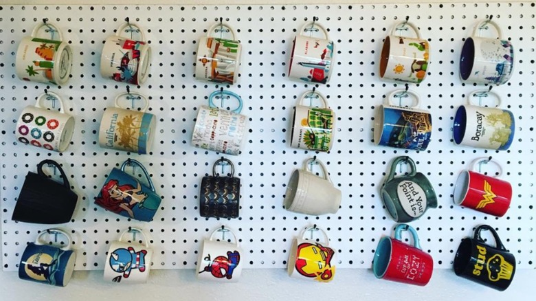 mugs hung on white peg board