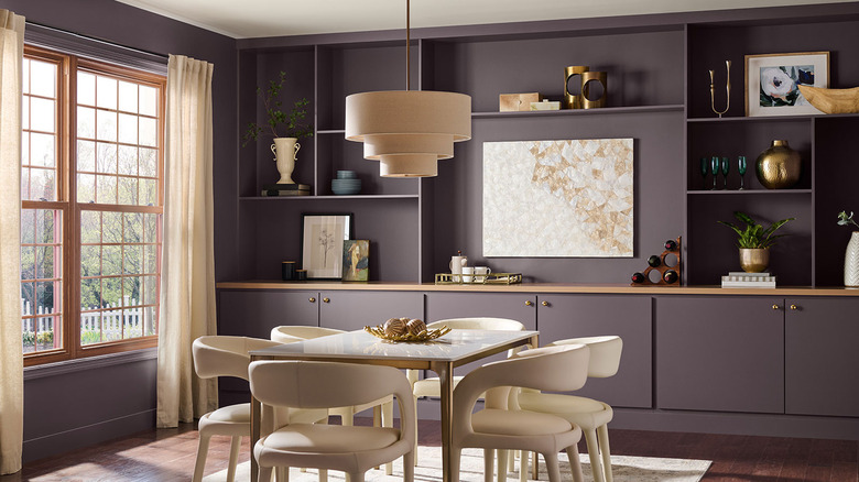 An eclectic dining room featuring built-in display shelves is painted Behr Curtain Call