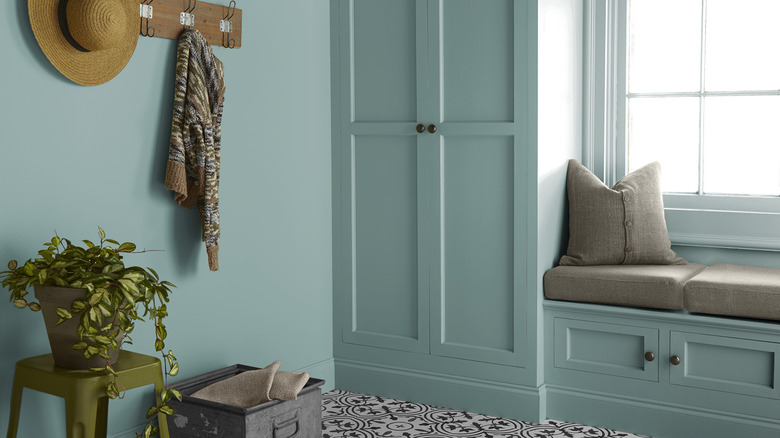 A mudroom with built-in cabinets is color-drenched in Behr Dragonfly