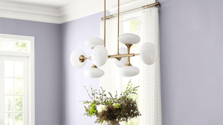 A modern chandelier hangs in a room painted Sherwin-Williams Modern Lavender