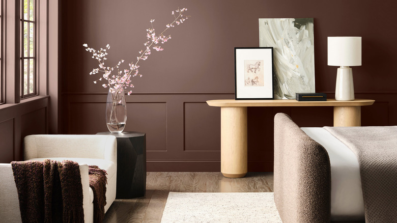 An elegant living room is color drenched with Sherwin-Williams Rojo Marrón