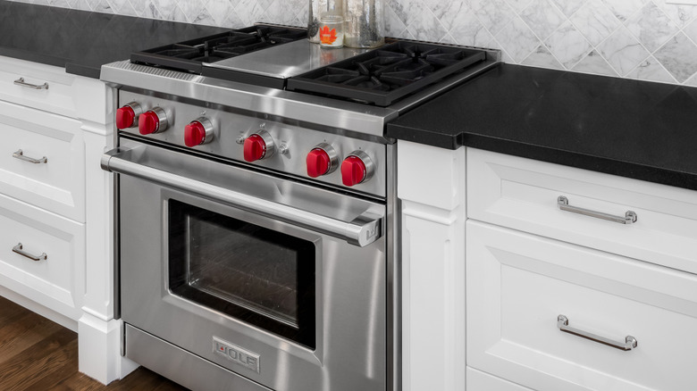 A Wolf oven in a kitchen with bright red knobs