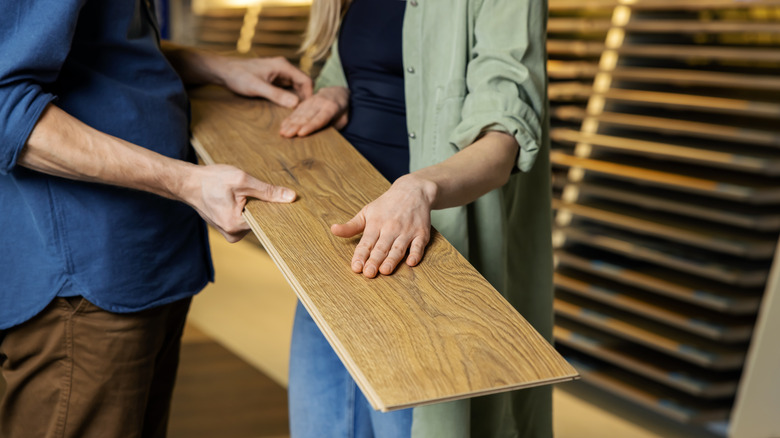 A young couple looks at a flooring sample