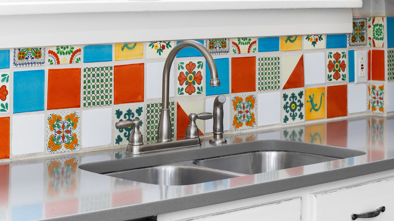 Kitchen with colorful tiled backsplash and grey countertops