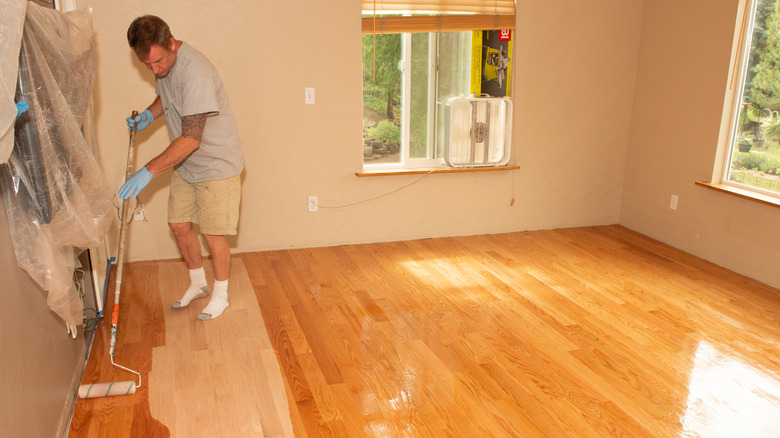 person adding stain or top coat to red oak hardwood floors