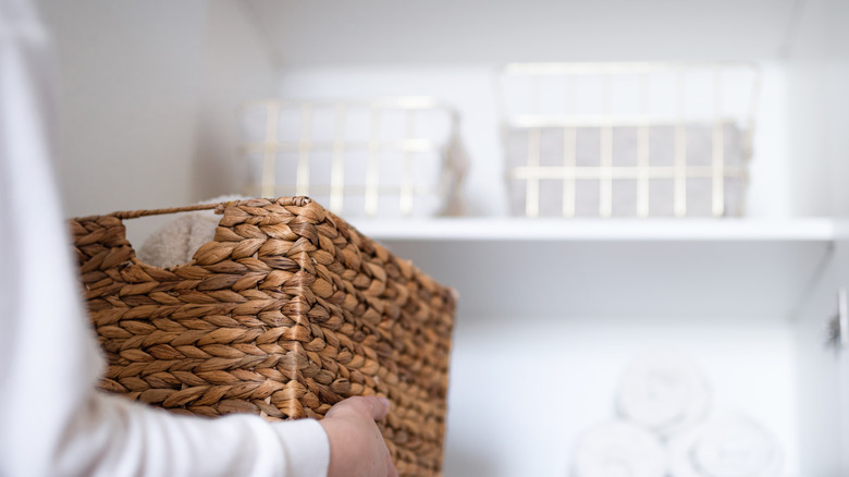 Person placing wicker basket on shelf