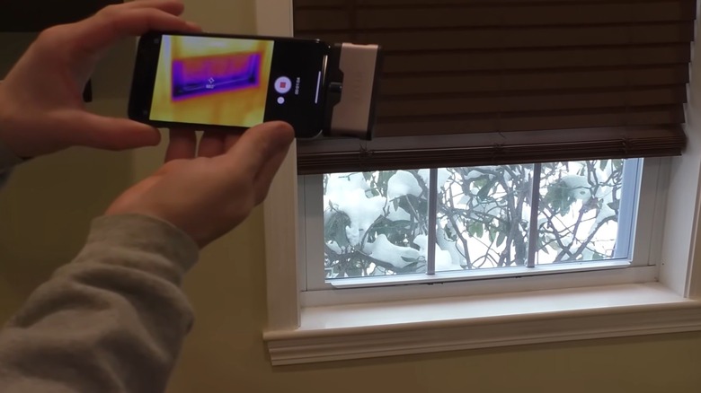 Person holding a smartphone and using a thermal imaging app