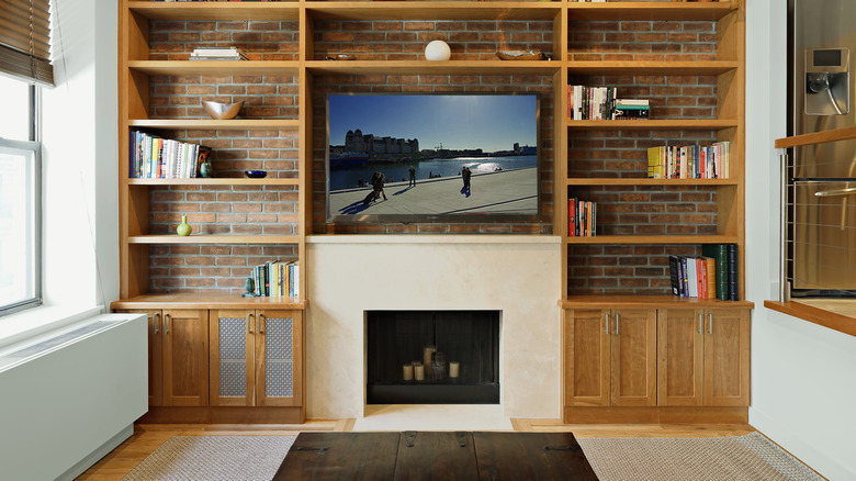 A TV above a fireplace in a living room.