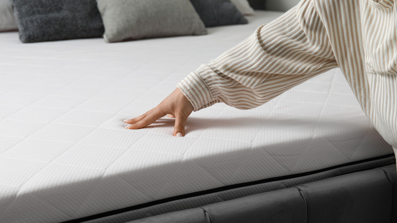 A person presses their hand into a plush, all-foam mattress.
