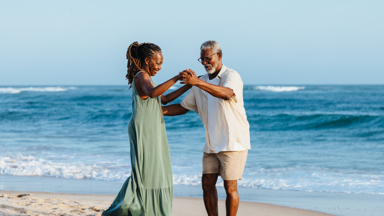 Happy older African American couple dancing on a beach