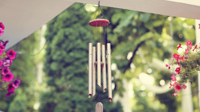 silver wind chime hanging next to plant