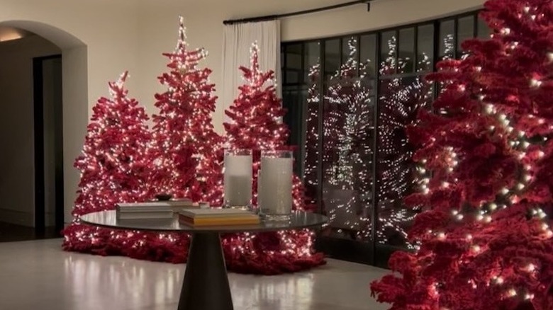 Red Christmas trees adorned with ample string lights