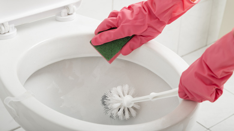 Cleaning toilet with gloves on