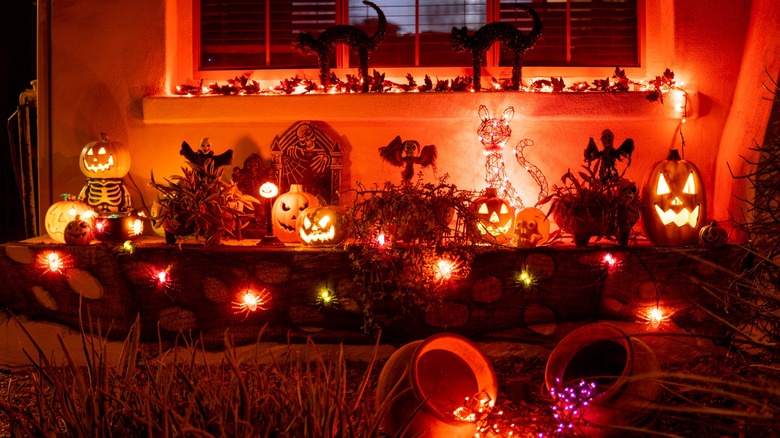 Halloween decorations on a porch in front of a house at night