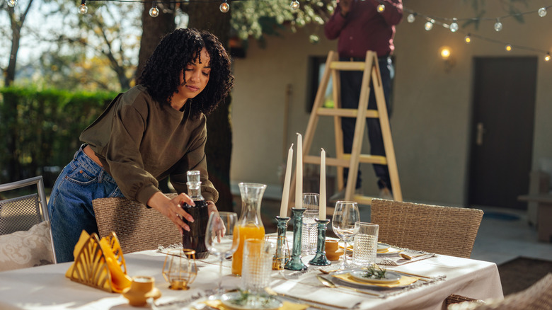 Woman setting table on outdoor patio