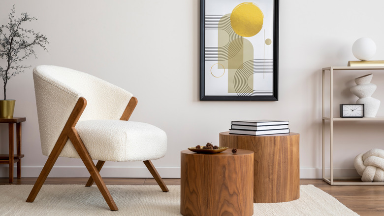 Boucle accent chair beside small wood side tables