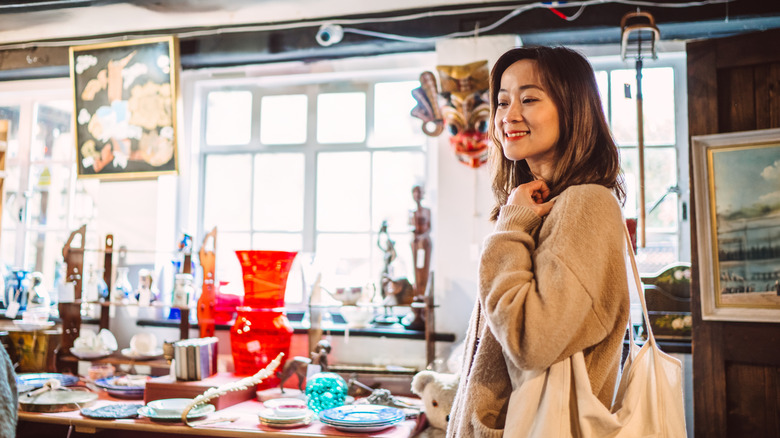 A person shopping for home decor in a thrift store