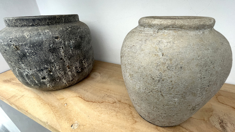 Two vintage stone planters on a table