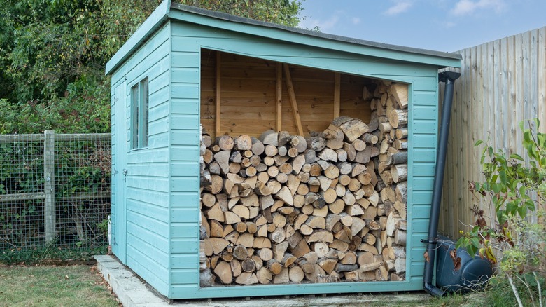 Blue log shed full of wood