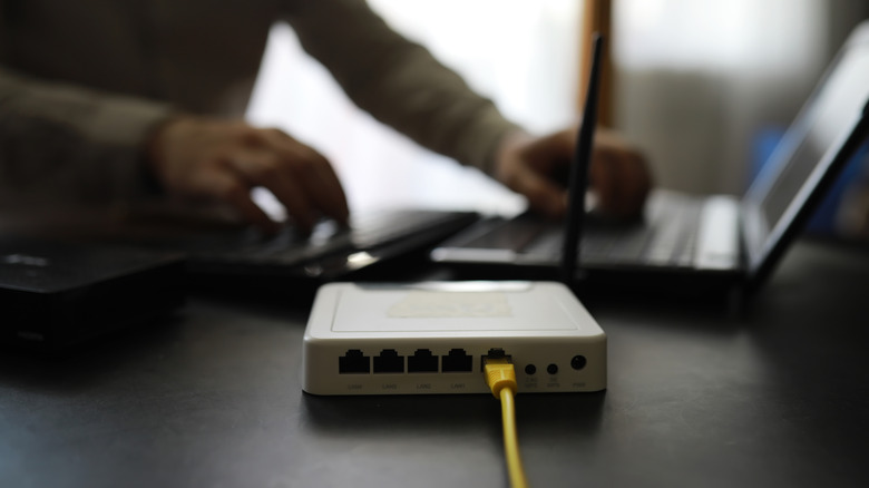 Wireless router with person on laptop in background