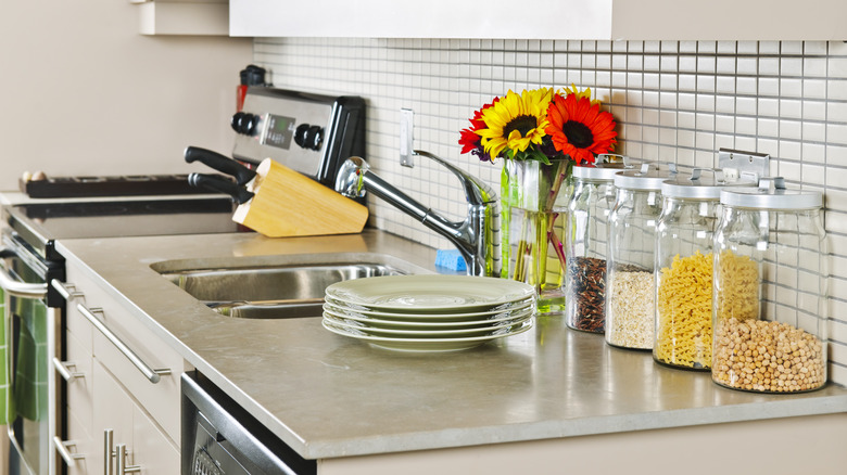 A small but modern kitchen with a natural stone countertop.