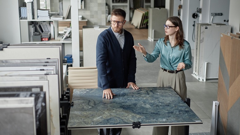 A man and woman discuss countertop trends and options in a kitchen supply showroom.