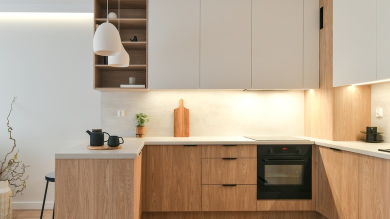 warm, neutral kitchen with cream and wooden cabinets and pendant lights