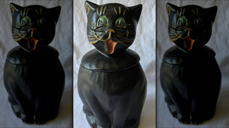 A black McCoy Coalby Black Cat Cookie Jar with green eyes and a smiling mouth