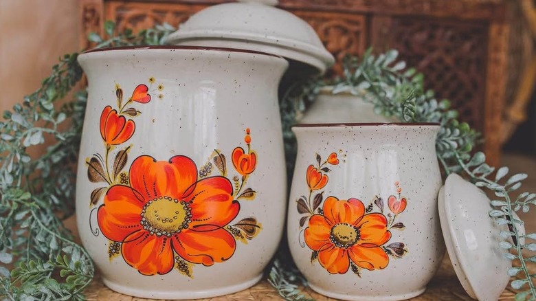 Set of two white ceramic canisters by Otagiri, one smaller than the other, each with a brilliant orange floral design