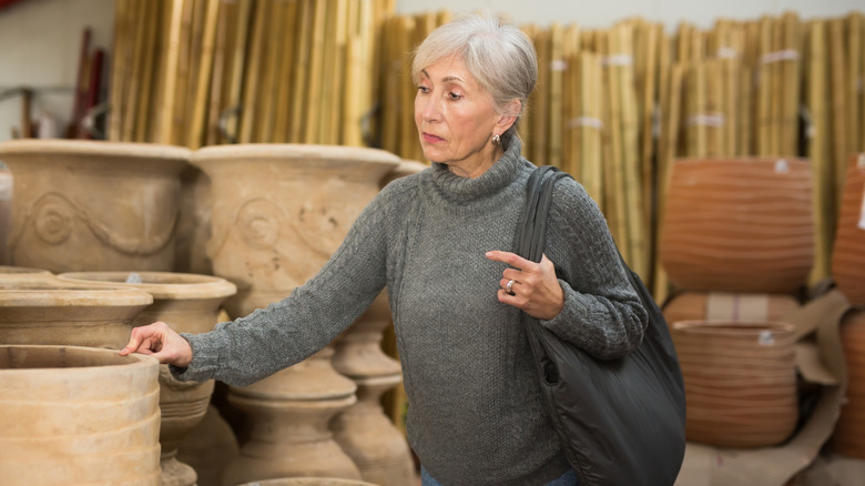 Woman shops for antique planters.