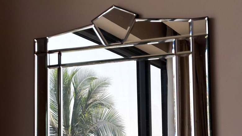 A geometric Art Deco mirror hung on a wall