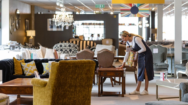 Person looking at a small table inside a furniture showroom