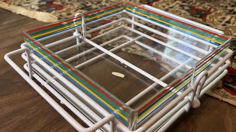 A Buffet Ware Napkin Caddy with Decorated Plastic Holder on display on a table