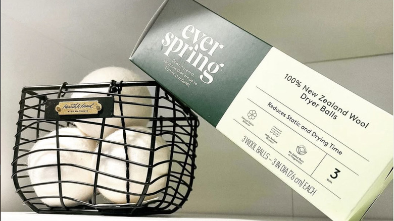 Three dryer balls in a wire basket displayed next to Everspring packaging