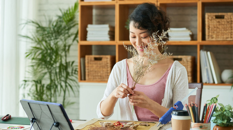 Woman making art with plant clippings