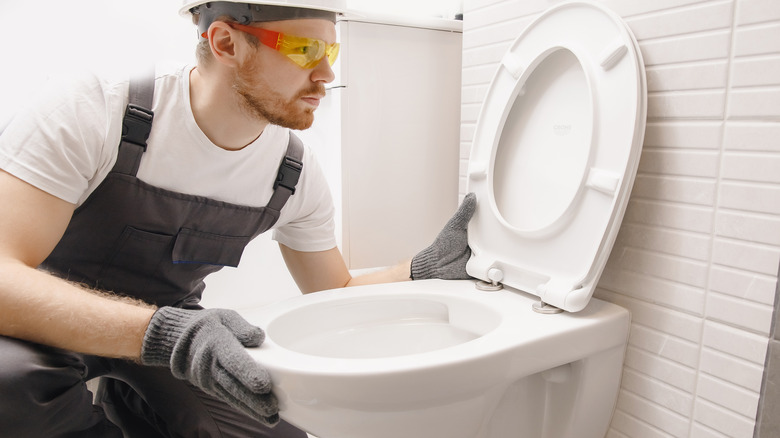 Worker installing a toilet
