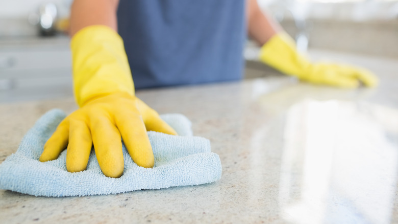 person wiping countertop