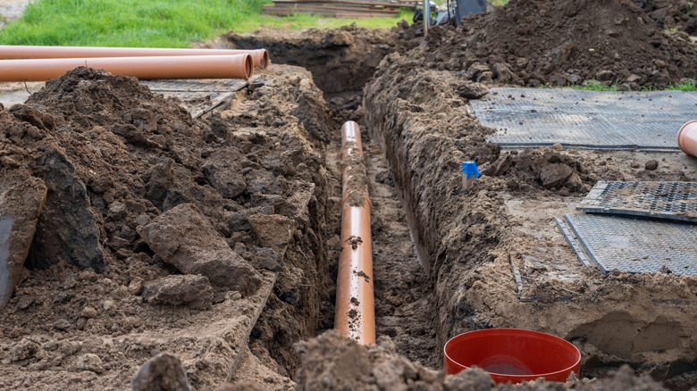 Sewer lines being placed in a trench in a front yard